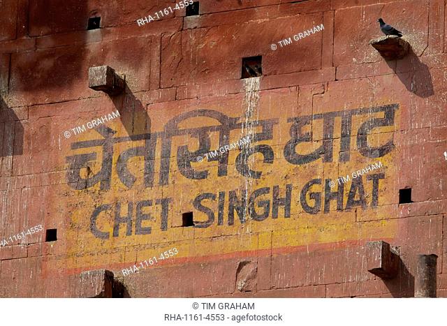 Sign in Indian script and English for Chet Singh Ghat with mynah birds and pigeons roosting in niches in holy city of Varanasi, India