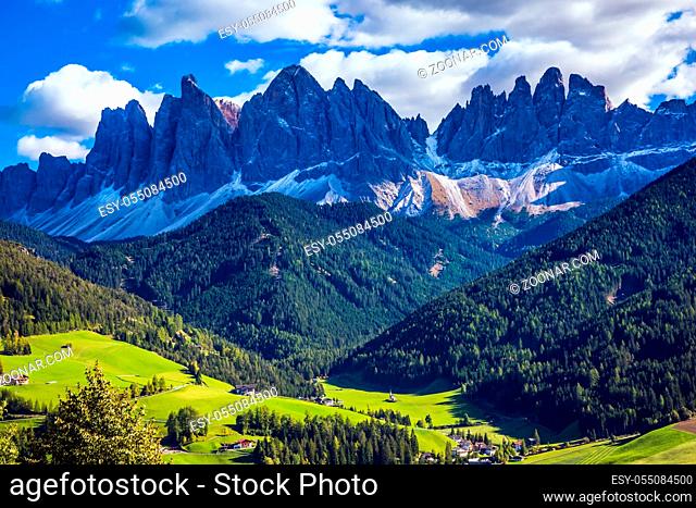 Odle mountain peaks surround the green alpine meadows of the valley. Dolomites, Val de Funes valley. Lovely sunny day in Nature Park Puez-Odle