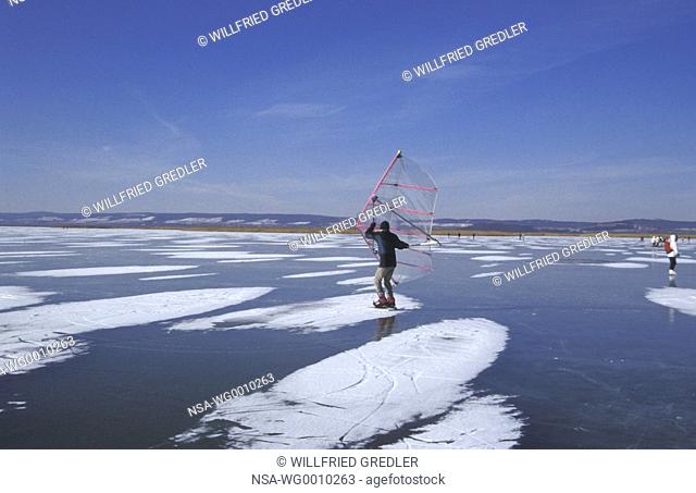 Ice skater with sail at the Neusiedler See in winter