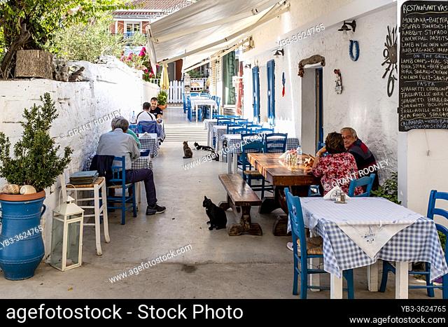 Tourists/Visitors and Local Cats At A Restaurant On Paxos Island, Greece