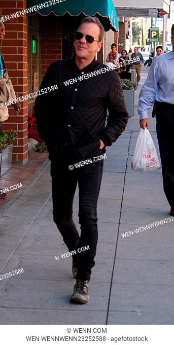 Kiefer Sutherland dressed all in black in skinny jeans and old scruffy boots out running errands in Beverly Hills wearing aviator sunglasses Featuring: Kiefer...