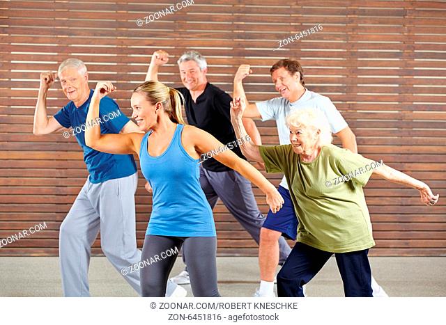 Lächelnde Senioren tanzen gemeinsam im Kurs im Fitnesscenter