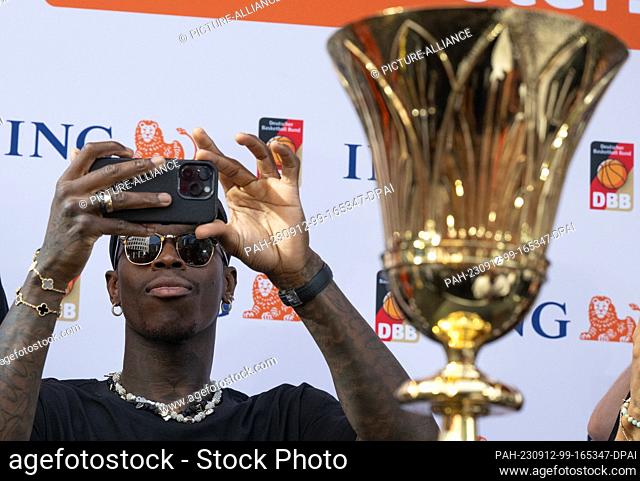 12 September 2023, Hesse, Frankfurt/Main: Dennis Schröder, captain of the national basketball team, stands next to the trophy at the team's reception in...