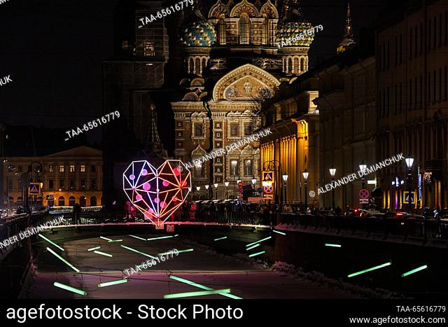 RUSSIA, ST PETERSBURG - DECEMBER 10, 2023: Street lights line up along the Griboyedov Canal, with the Church of the Saviour on Blood in the background