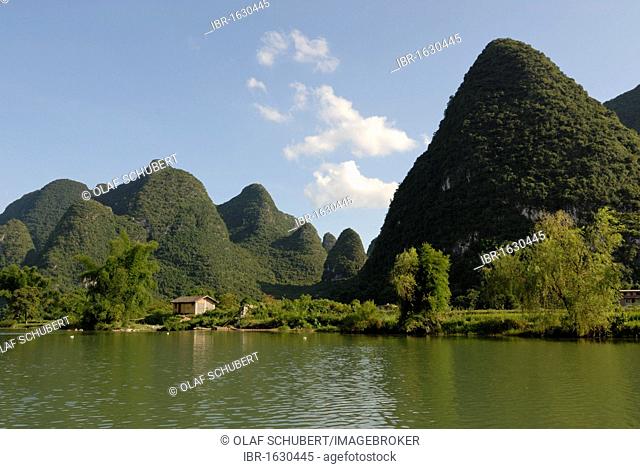 Karst rocks at the Yulong river with bamboo and wooden fishing hut in Yangshuo, Guilin, Guangxi, China, Asia