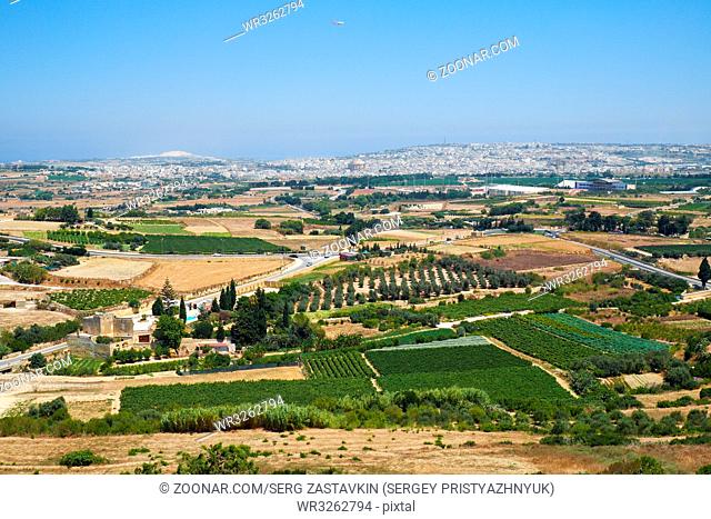 View from the Mdina defensive wall to the countryside with vineyards and gardens surrounding the old Malta capital and to the town Mosta with the huge dome of...