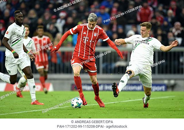 Robert Lewandowski (l) of Munich and Waldemar Anton of Hannover vie for the ball during the German Bundesliga football match between Bayern Munich and Hanover...