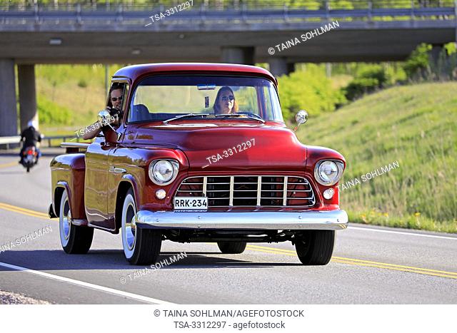 Salo, Finland. May 18, 2019. Woman drives a mid-1950s Chevy pickup, the man on passengers seat is photographing on Salon Maisema Cruising 2019