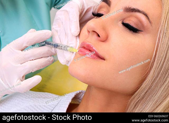 Beautiful girl on rejuvenation procedure in beauty clinic filler injection. Injection in her lips
