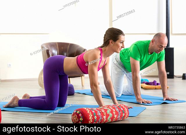 Portrait of man and woman doing yoga on exercise mat