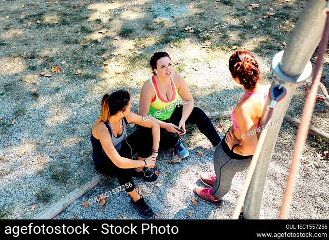 Friends taking break from exercise in park