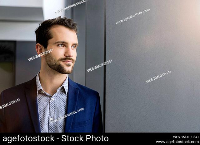Portrait of young businessman looking at distance
