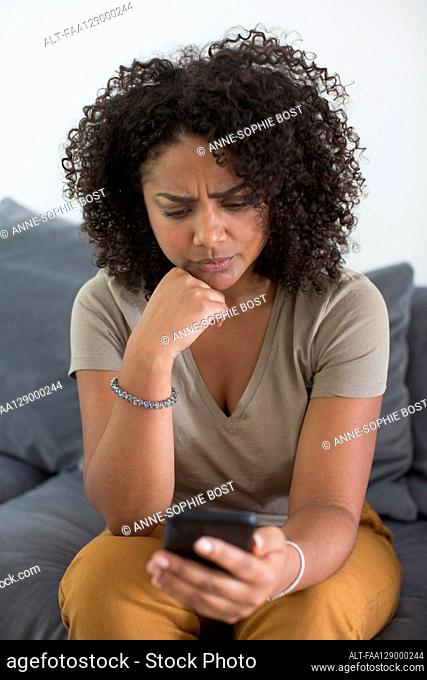Woman reading message on smart phone