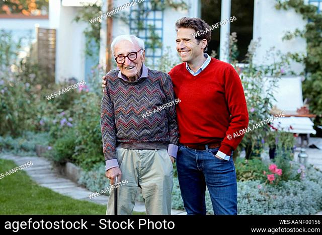 Happy man with father in backyard