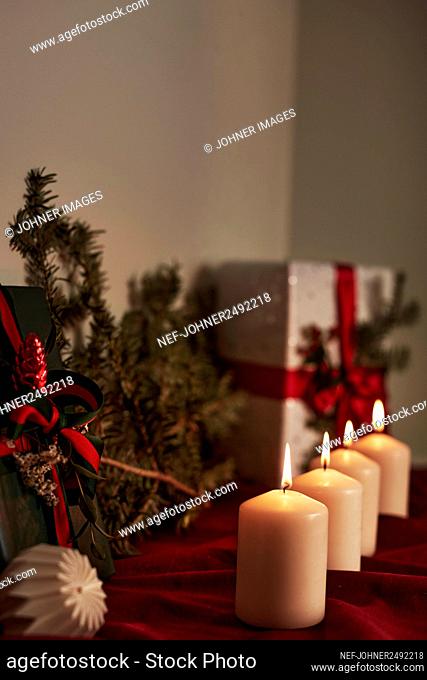 Advent candle in front of Christmas presents