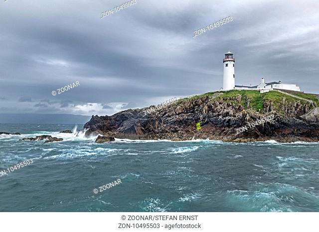 Fanad Head Lighthouse on rocky cliff, rain shower, County Donegal, Ireland, Europe