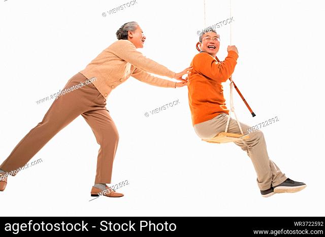Happy old couple on the swings