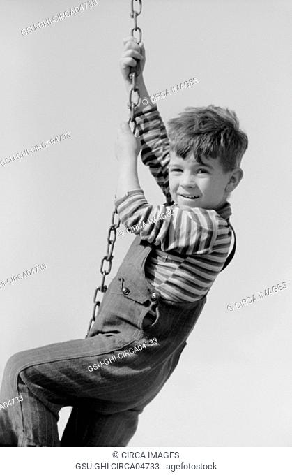 Portrait of Young Boy Hanging on Swing Chain at Playground, Child of Migratory Worker, Weslaco, Texas, USA, Arthur Rothstein for Farm Security Administration