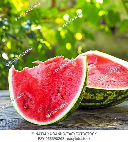 cut a ripe watermelon on a wooden table, copy space