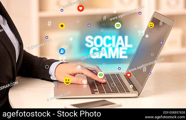 Freelance woman using laptop with SOCIAL GAME inscription, Social media concept