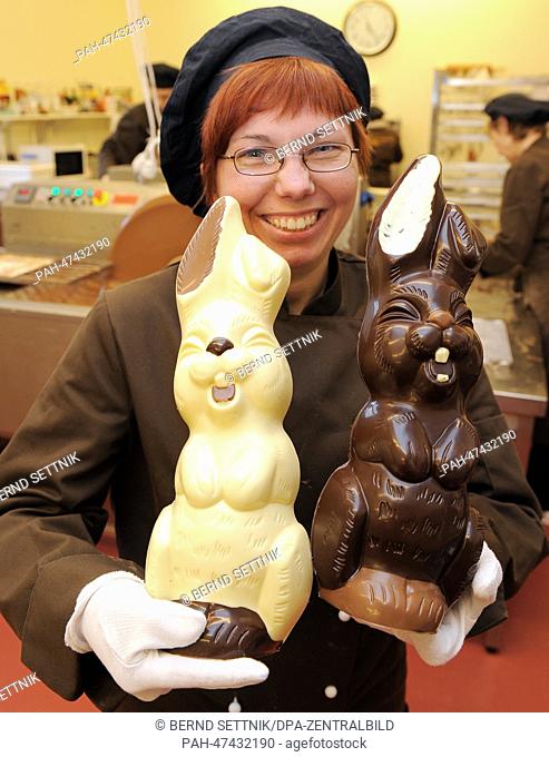 Sandra Hendel carries two 40 centimeter chocolate bunnies at the chocolate factory in Hammelspring, Germany, 19 March 2014