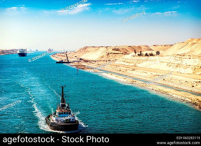 Der Suezkanal - eine Schiffskolonne durchfährt den neuen, östlichen Erweiterungskanal, eröffnet im August 2015, im Vordergrund ein Schlepper