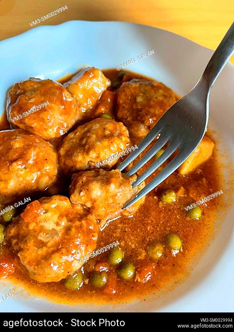 Eating meatballs with vegetables sauce. Spain