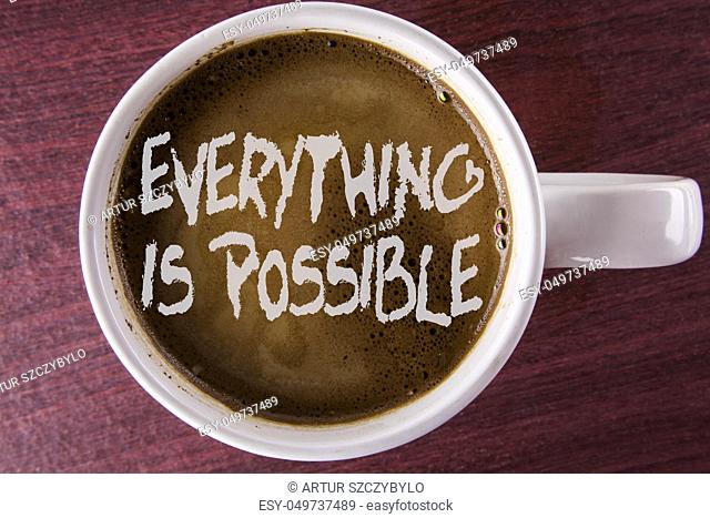 Writing note showing Everything Is Possible. Business photo showcasing All you think or dream can become true Optimistic written Coffee in White Cup the wooden...
