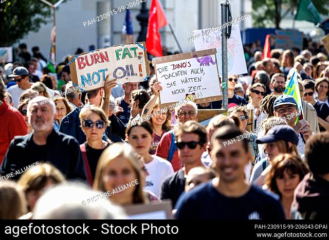 15 September 2023, Bavaria, Munich: Participants of the demonstration of the climate protection movement Fridays for Future hold up signs with the inscriptions...