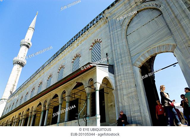 Sultanahmet Camii The Blue Mosque exterior wall of the Courtyard with minaret and visiting sightseeing tourist