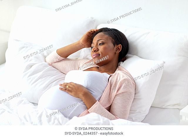 pregnant woman lying in bed at home
