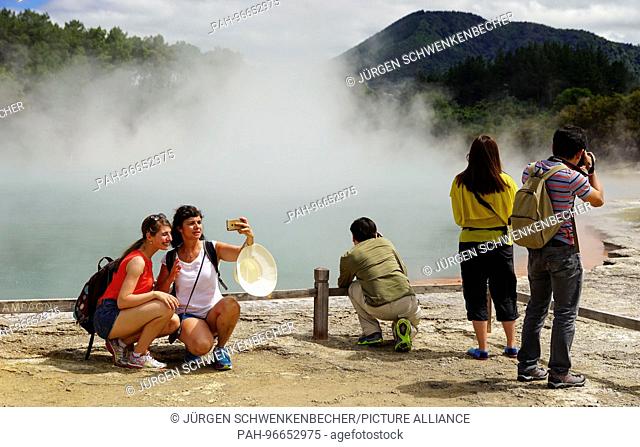 Selfies in front of the Champagne Pool at Wai-O-Tapu Thermal Wonderland near Rotorua are popular with tourists. The region on the North Island of New Zealand is...