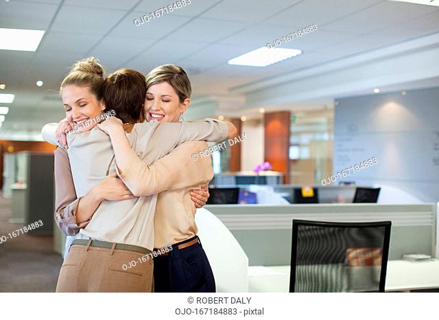 Businesswomen hugging in office