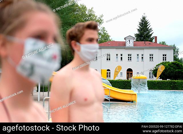 20 May 2020, Saxony, Leipzig: A young couple is standing in the Schreberbad and wearing mouthguards. The city of Leipzig informed at a press meeting about the...