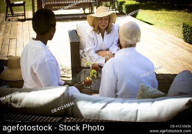 Senior women friends talking on summer patio