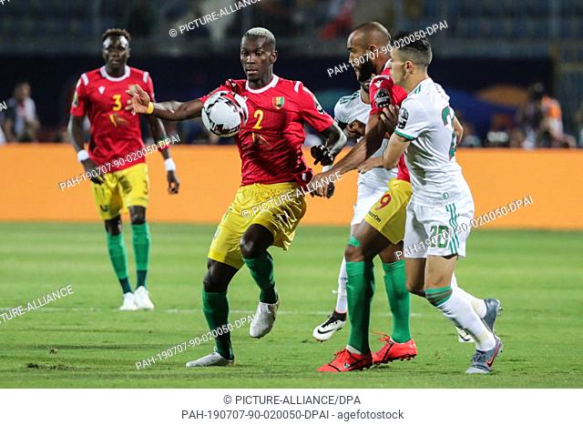 07 July 2019, Egypt, Cairo: Guinea's Mohamed Yattara vies for the ball with Algeria's Youcef Atal during the 2019 Africa Cup of Nations round of 16 soccer match...