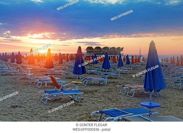 Italy, Friuli-Venezia Giulia, Province of Udine, Lignano Sabbiadoro, Beach with sun loungers in the evening, Terrazza a Mare in the background