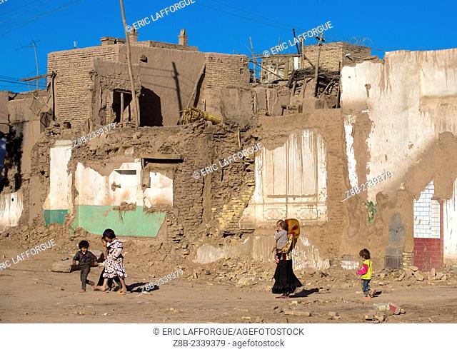 family passing in the Demolished Old Town Of Kashgar, Xinjiang Uyghur Autonomous Region, China