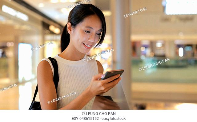 Woman using smart phone in shopping mall