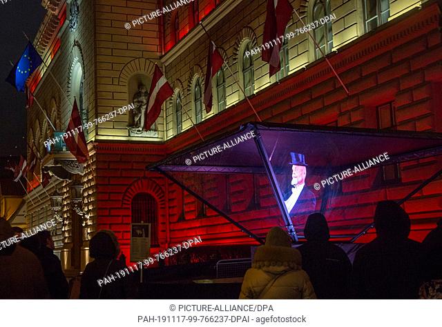 16 November 2019, Latvia, Riga: A light installation shows a hologram of the first Latvian president Janis Cakste in front of the parliament