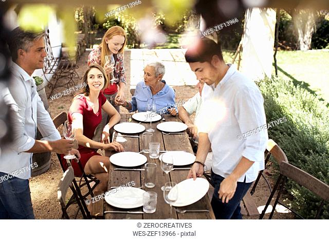 Family setting table outside for lunch