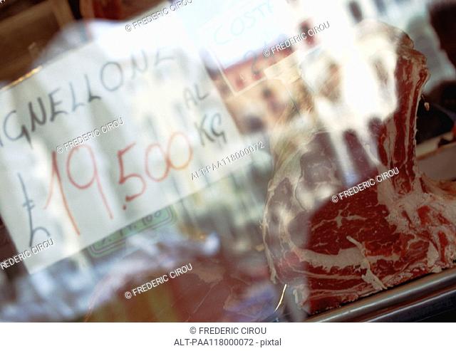 Meat and price behind glass pane
