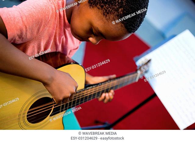 High angle view of boy playing guitar