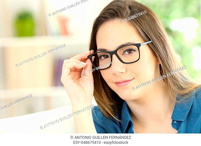 Portrait of a serious woman posing wearing eyeglasses at home