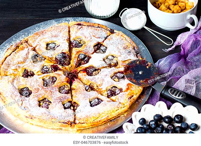 Blueberry Fruit sweet pie and a roller cutter knife