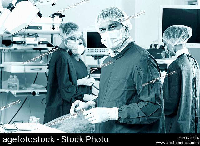 Surgeon looking at camera with colleagues