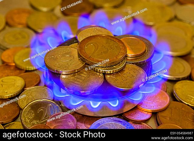 Coins of on the gas burner of the kitchen stove - business background