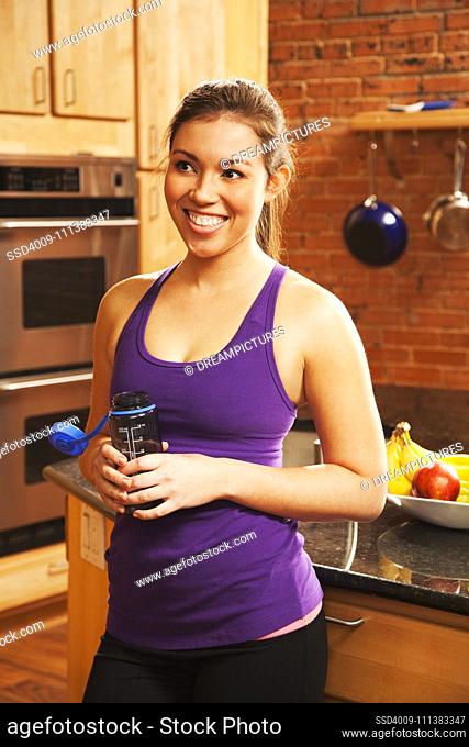 Hispanic woman drinking water after exercise