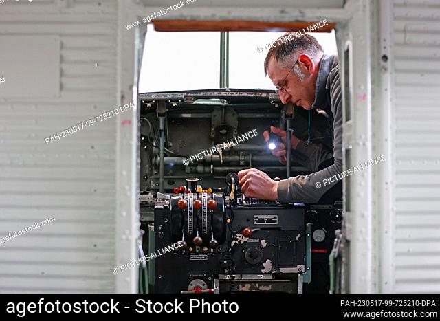 17 May 2023, Saxony-Anhalt, Wernigerode: Mathias Kögler of the Wernigerode Aviation Museum examines the cockpit of a Ju 52 that has recently become part of the...