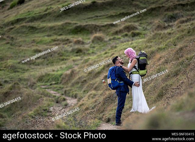 Bridal couple with climbing backpacks at hiking trail, Urkiola mountain, Spain